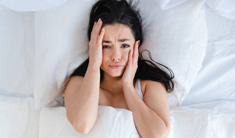 sad-young-caucasian-woman-lying-in-the-bed-with-wh-2023-11-27-04-59-23-utc-768x512